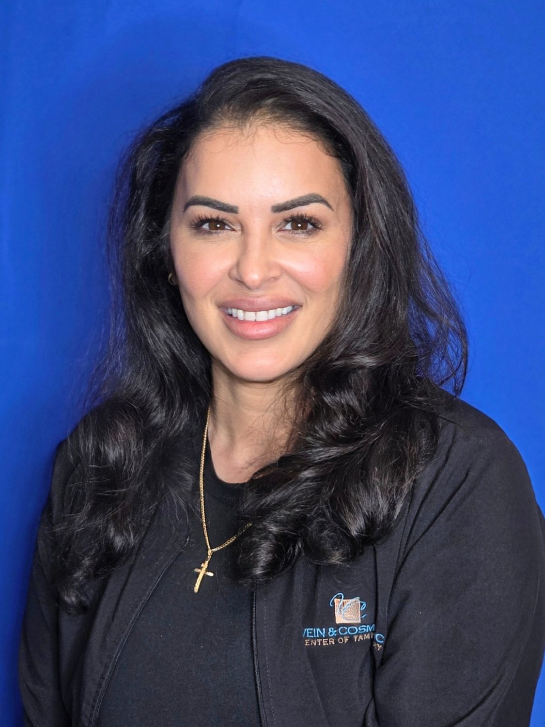 Portrait of a woman with dark hair smiling.