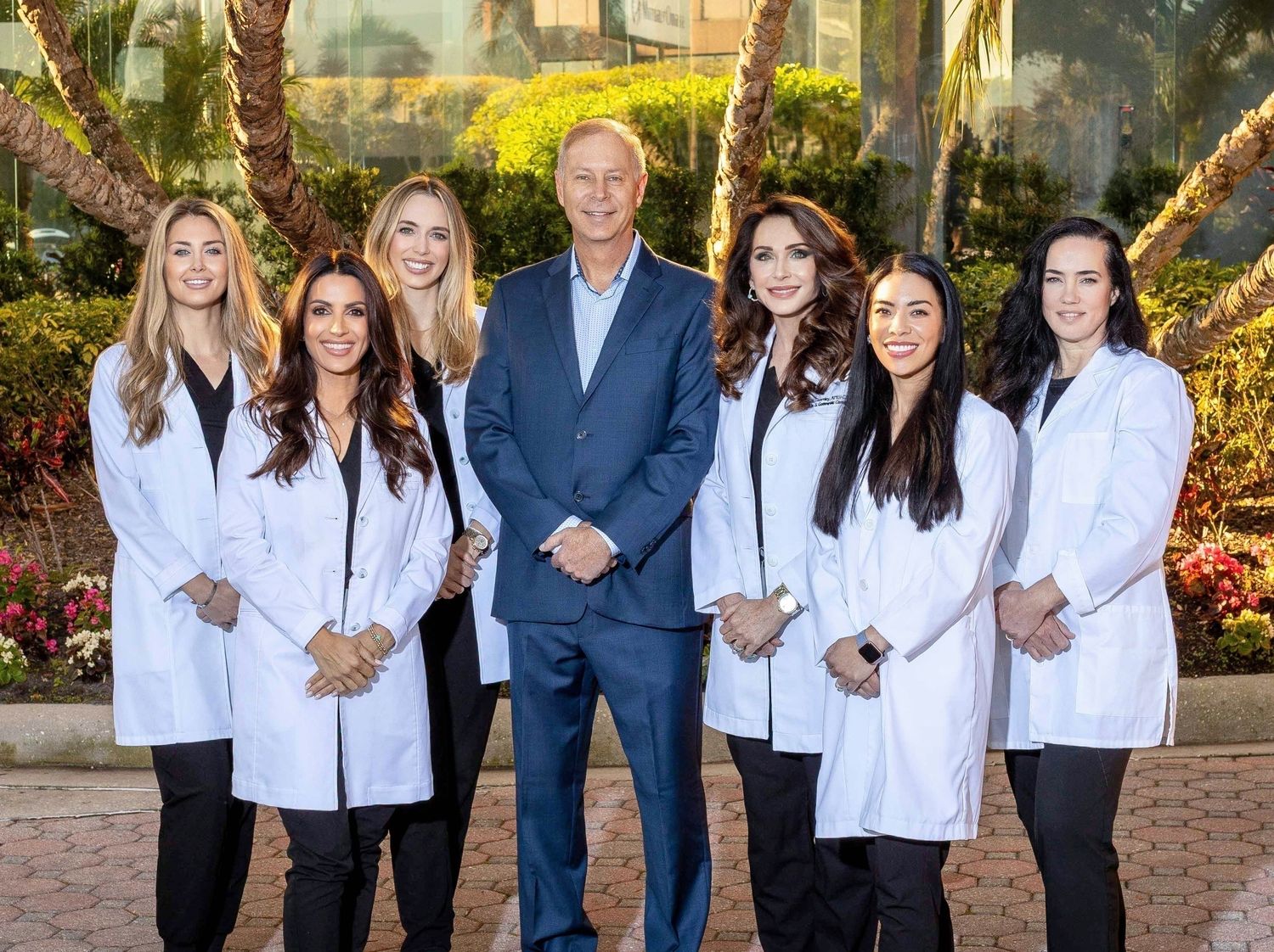 Team of medical professionals posing together outdoors.