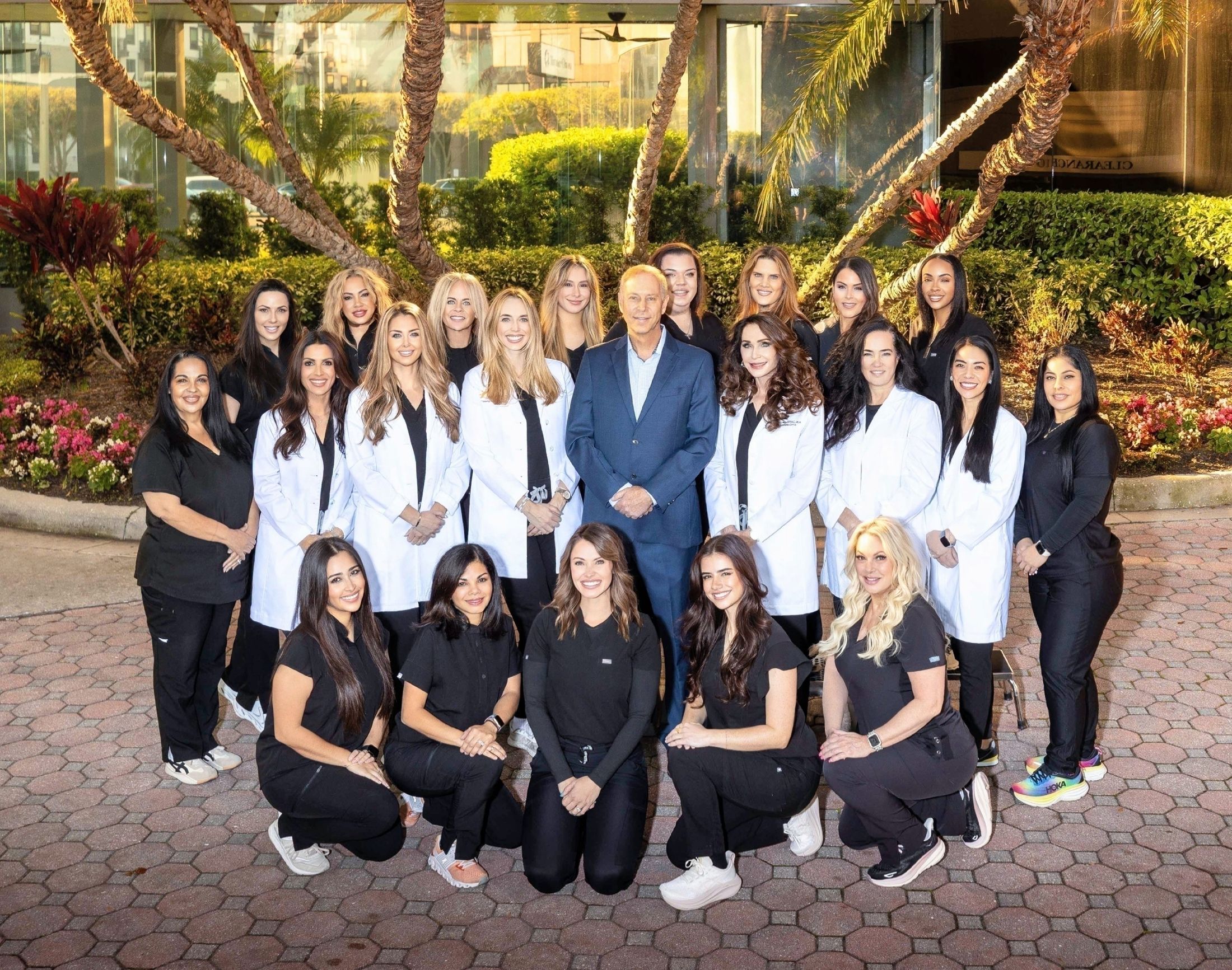 Medical team posing outdoors with flowers.