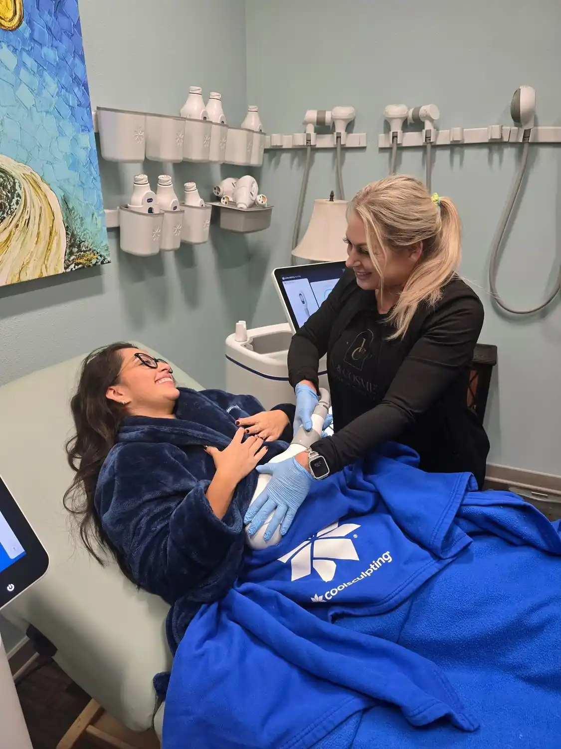 Provider applying a CoolSculpting Elite applicator to a patient's abdomen during treatment