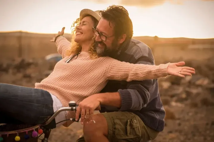 energetic middle-aged couple on bike together