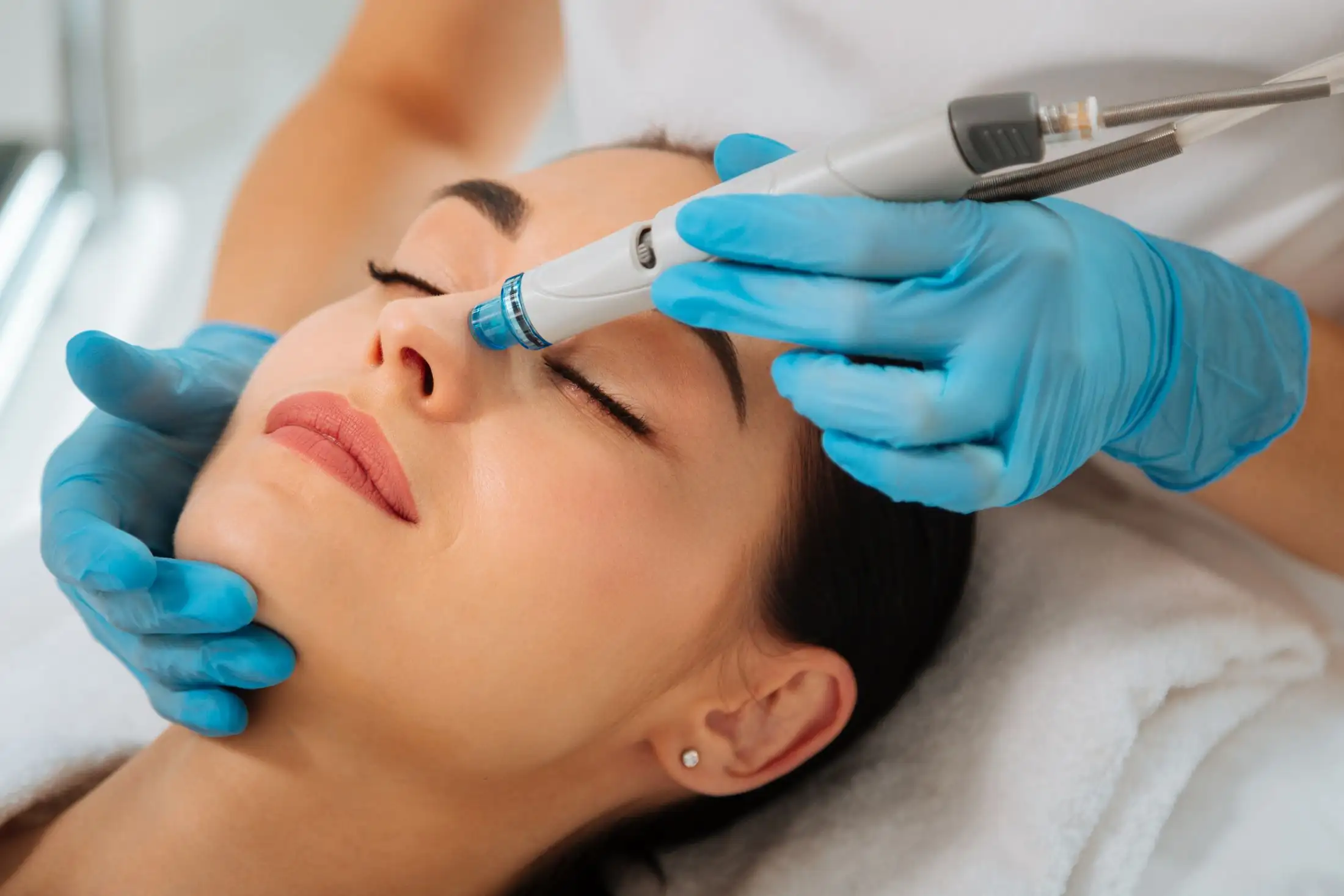 woman receiving hydrafacial treatment to exfoliate and hydrate skin