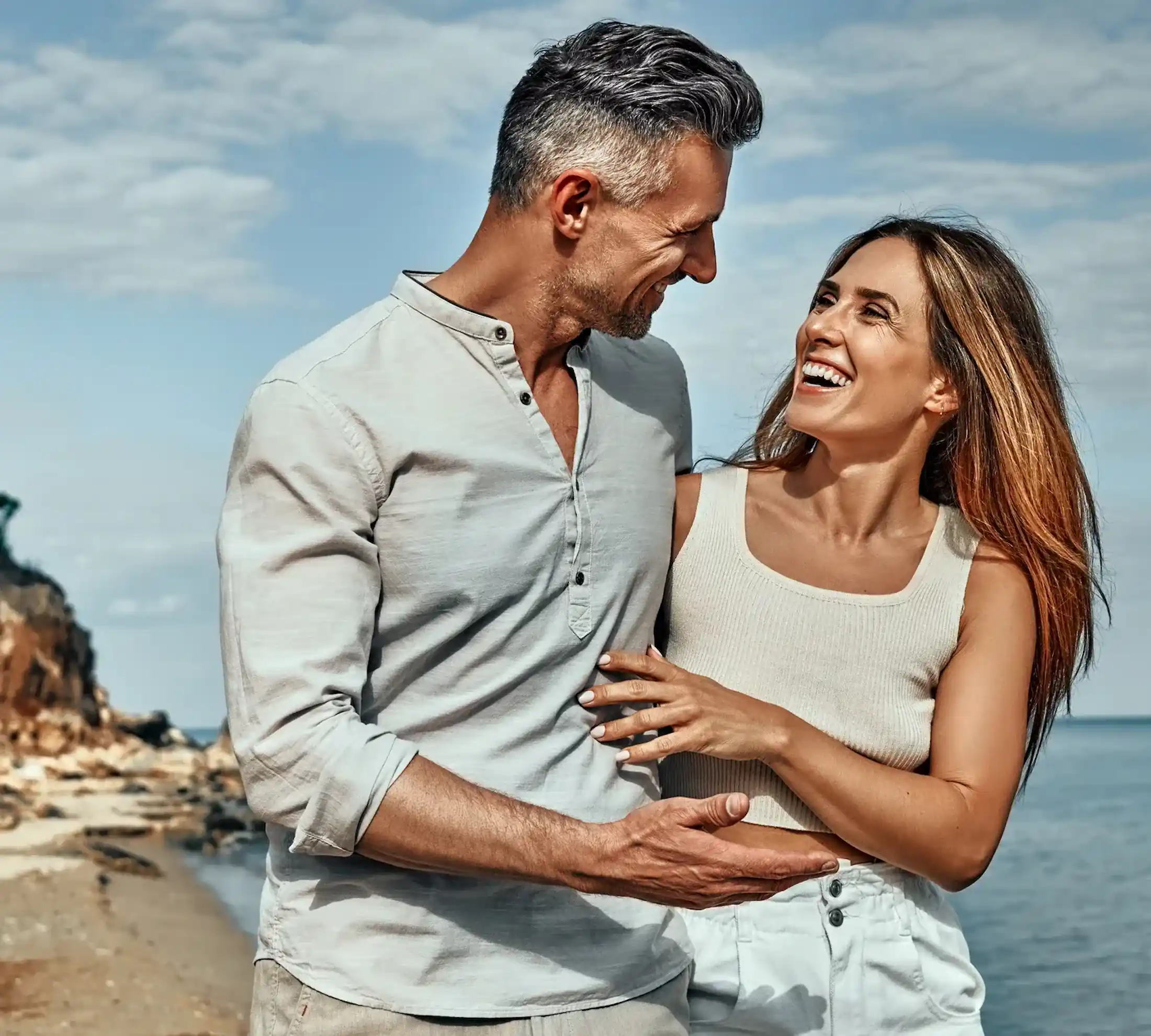 Mature couple on the beach enjoying the benefits of peptide therapy