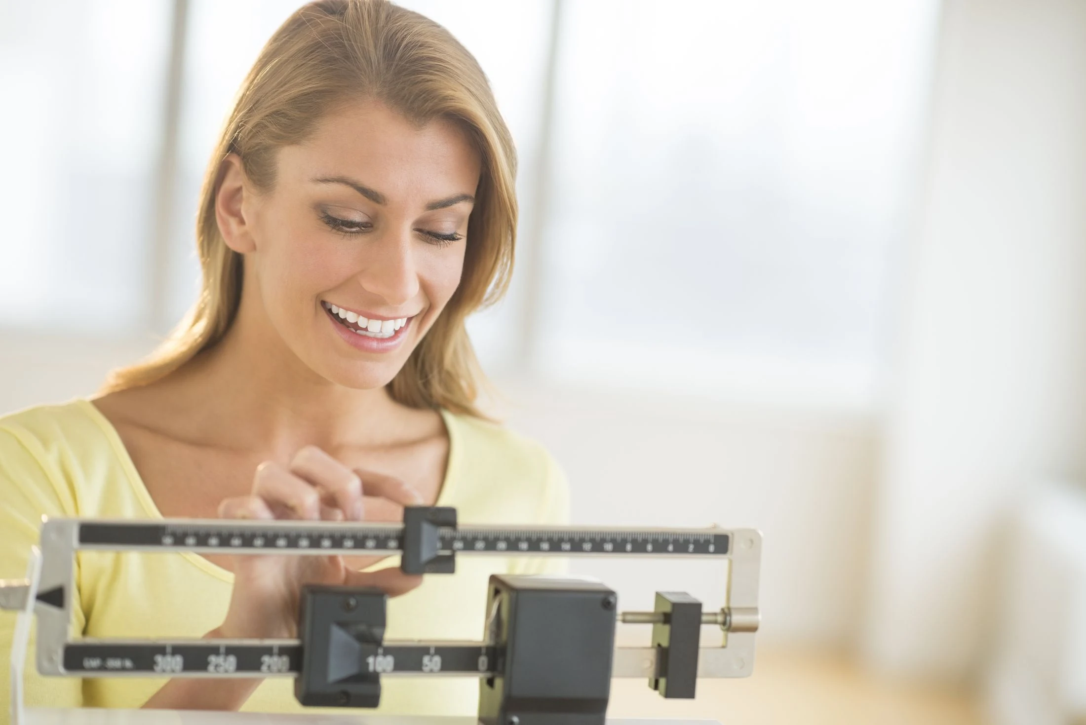 Woman adjusting the weights on a scale at the gym