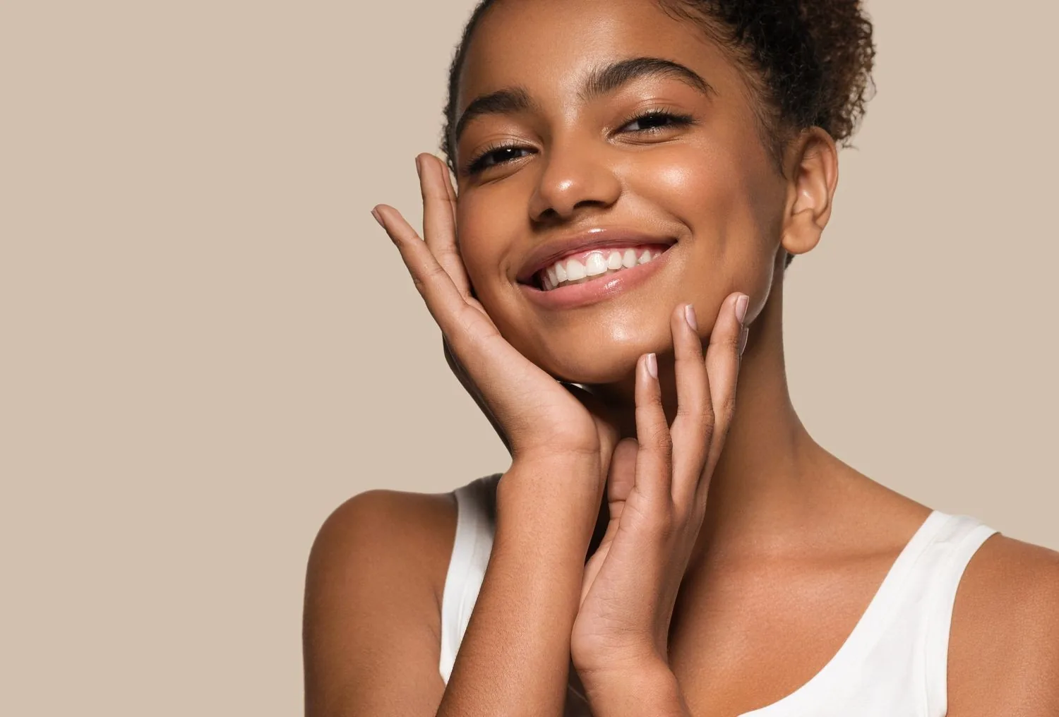 beautiful woman touching slender jawline and radiant skin after Sofwave treatment