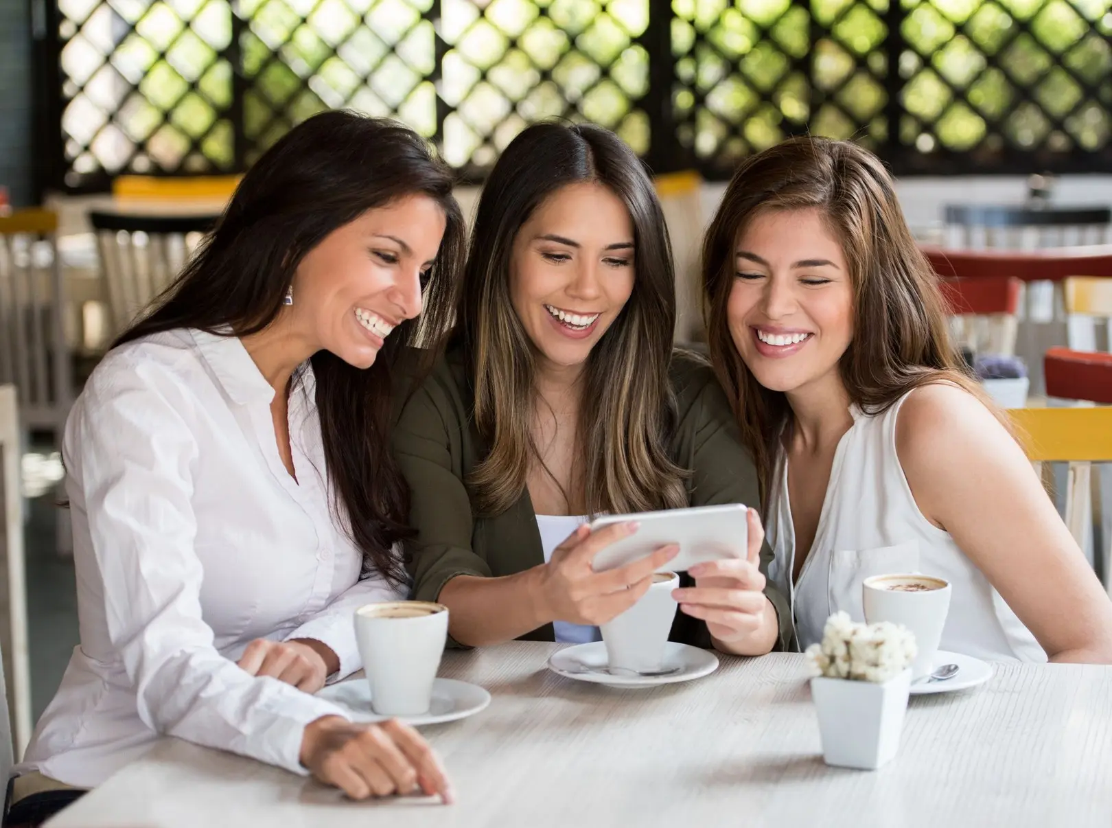 group of women watching a video at happy hour