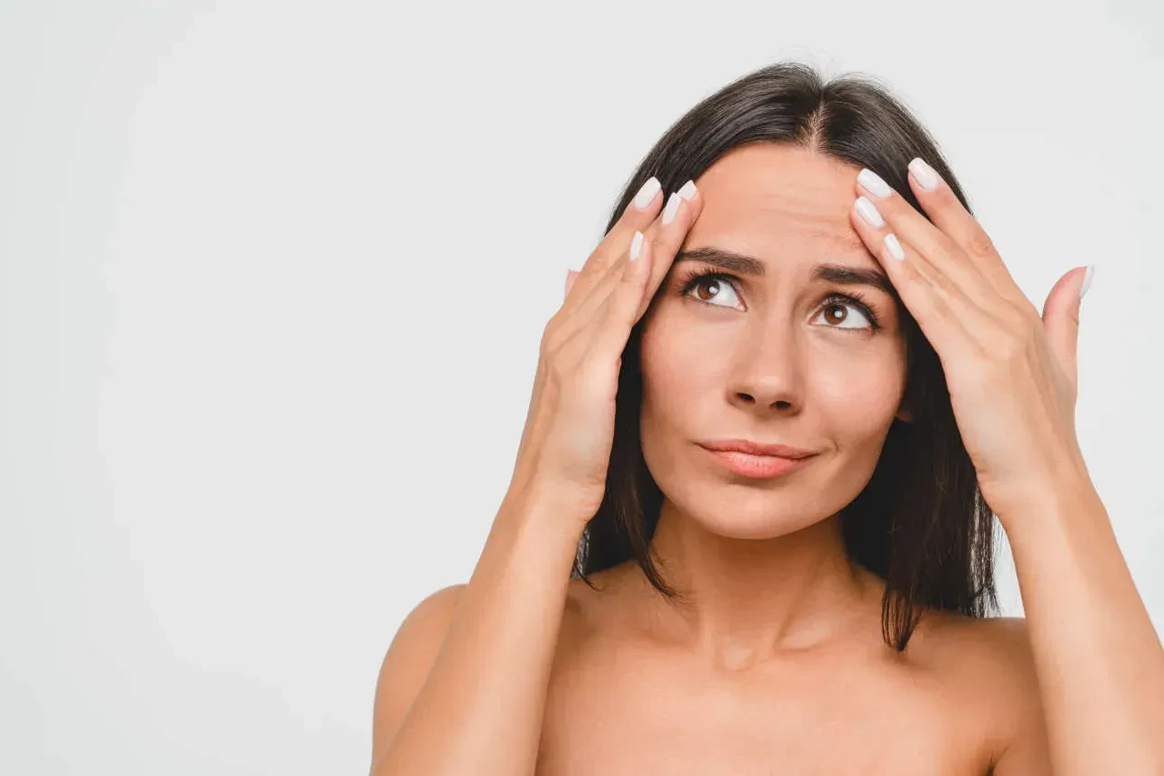 woman touching wrinkles on forehead